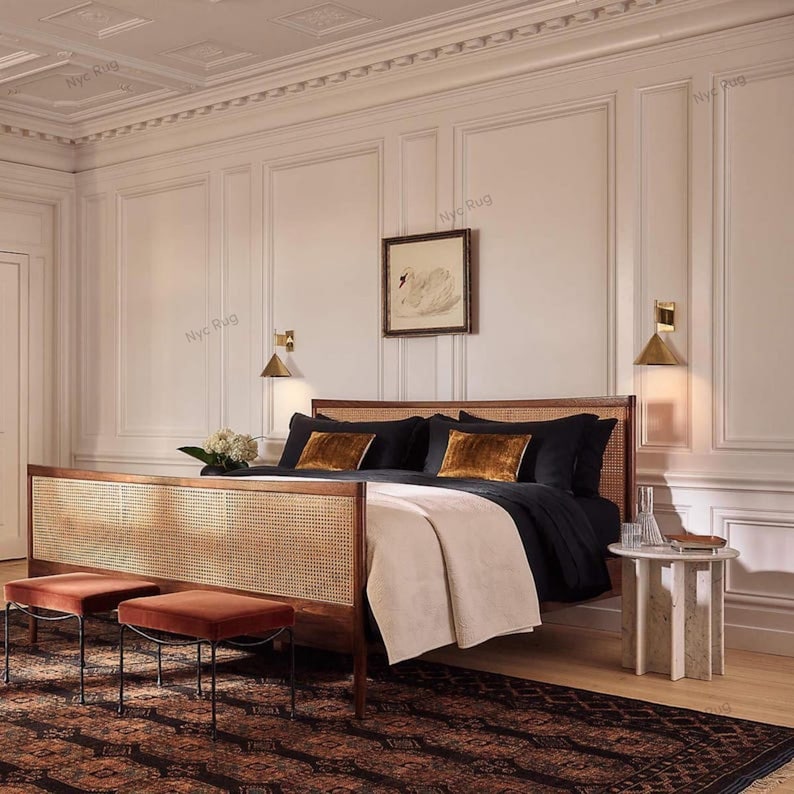 Pu&ograve; includere: Una camera da letto con un letto in legno con testiera e pediera intrecciate. Il letto ha biancheria da letto nera e cuscini decorativi in velluto. Due piccoli sgabelli in velluto color ruggine sono di fronte al letto e un tappeto fantasia copre il pavimento.