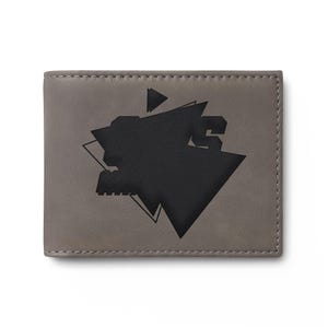 May include: A gray bi-fold wallet with a black geometric design. The design features a large, abstract shape with a triangle and lines. The wallet is made of a smooth material and has a stitched border.