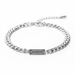 Puede incluir: Pulsera plateada con diseño de cadena de bordillo. La pulsera presenta un dije rectangular con un gráfico de cancha de tenis. La cadena ajustable tiene un cierre de mosquetón. Un accesorio deportivo.