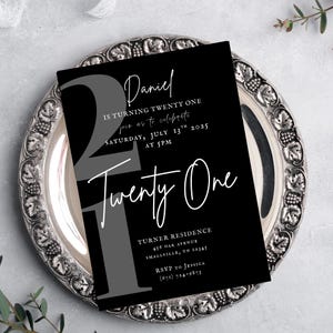 Puede incluir: Una tarjeta de invitación en blanco y negro para una celebración de cumpleaños número veintiuno. El diseño presenta el nombre "Daniel" en cursiva, el número "21" en gris y las palabras "Twenty One" en una fuente elegante. La invitación incluye detalles del evento.