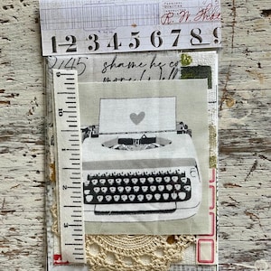 May include: A collage of paper ephemera featuring a typewriter print with a heart, numbers, and handwritten text. A measuring tape is included. The color palette is neutral with cream, gray, and white tones.