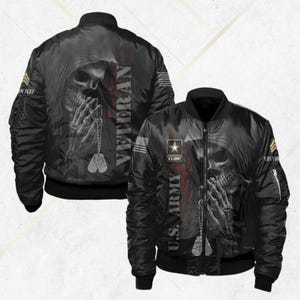 May include: Black bomber jacket featuring a skull design with praying hands and dog tags. The jacket has the text "Veteran" and "U.S. Army" printed on it. The jacket has a zipper closure and multiple pockets. The design is detailed and the jacket appears to be made of a durable material.