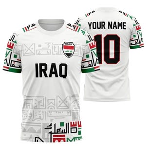 May include: White football shirt featuring the word "IRAQ" in black. The shirt displays the Iraqi flag and the word "IRAQ". The number "10" is on the back with the text "YOUR NAME". The sleeves have green, red, and white accents.