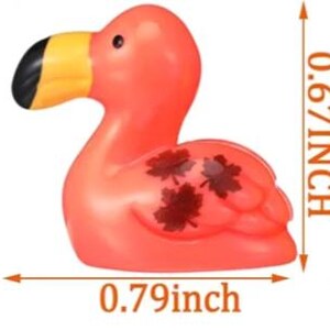 May include: A pink flamingo-shaped bath toy with a yellow beak and black tip. The toy has three dark red leaf designs on its side. It measures approximately 0.79 inches long and 0.67 inches high.