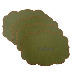 Op de afbeelding: Vier olijfgroene placemats met een geschulpte rand en bruine stiksels. De placemats hebben een rechthoekige vorm met een decoratieve rand. De tekst "fabricrush" is rechtsonder zichtbaar.