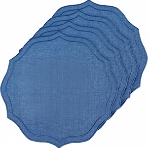 Op de afbeelding: Een stapel van zes blauwe placemats met een geschulpte rand. De placemats hebben een textuur en een effen blauwe kleur. De placemats zijn ontworpen voor diners en tafeldecoratie.
