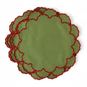 Può includere: Un set di tovagliette rotonde in tessuto verde oliva caratterizzate da un bordo smerlato rifinito con una vivace bordatura ricamata in rosso. Le tovagliette sono impilate in una disposizione circolare, evidenziando la forma e il contrasto.