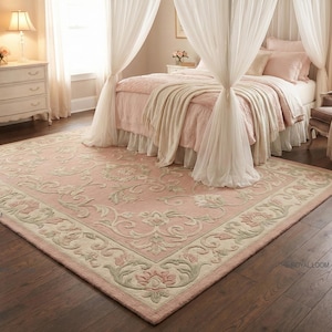 Puede incluir: Una alfombra rosa rectangular grande con un diseño floral y un borde crema. La alfombra está en un dormitorio con una cama, cortinas y una cómoda. Las dimensiones de la alfombra son aproximadamente 244 x 305 cm.