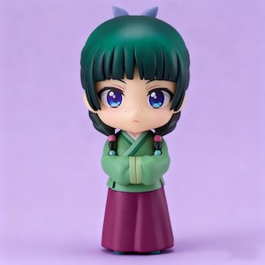 May include: A chibi-style figurine of a girl with green hair and a matching bow. She wears a green top and a purple skirt, with her arms crossed. The figurine has large blue eyes and freckles, set against a purple background.