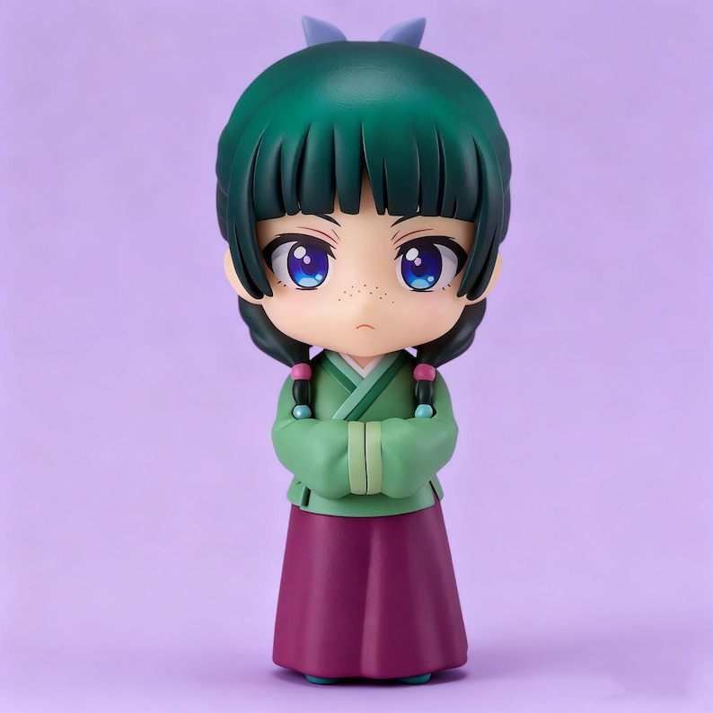 May include: A chibi-style figurine of a girl with green hair and a matching bow. She wears a green top and a purple skirt, with her arms crossed. The figurine has large blue eyes and freckles, set against a purple background.