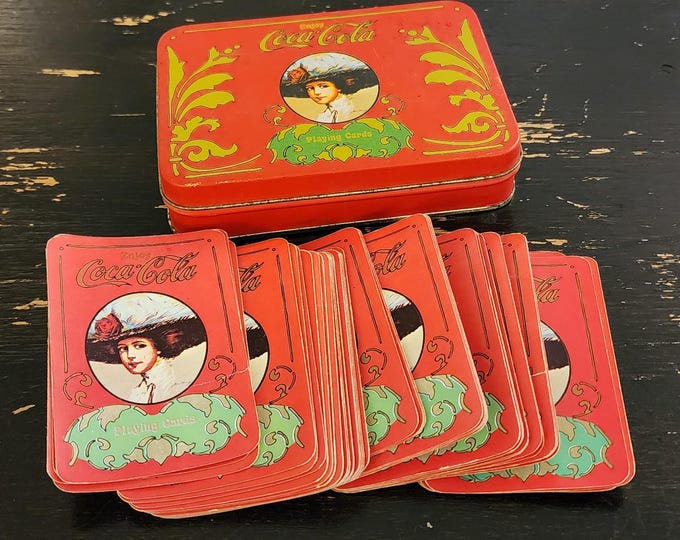 Vintage Coca-Cola deck of playing cards and a collectible tin. Coke