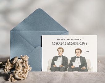 May include: A blue envelope and a greeting card with the text "DID YOU JUST BECOME MY GROOMSMAN?" and an illustration of two men in tuxedos. The card also has the word "Yep!" printed on it.