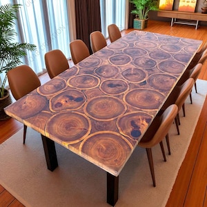 Puede incluir: Una gran mesa de comedor rectangular con un diseño único de rodajas de madera en la superficie. La mesa está sostenida por patas negras y rodeada de sillas de cuero marrón. La superficie de la mesa es un mosaico de rodajas de madera circulares.