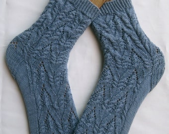 Peut inclure: Une paire de chaussettes bleues en tricot avec un motif de câble. Les chaussettes sont faites avec un point de dentelle délicat et ont une sensation douce et confortable.