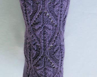 Peut inclure: Gros plan d'une chaussette tricotée violette avec un motif floral ajouré complexe. La chaussette est de couleur violet foncé unie et semble être faite à la main. Le motif présente un motif répété de feuilles et de vignes.
