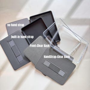 Pu&ograve; includere: Una selezione di custodie per tablet in grigio e nero, alcune con retro trasparente. Le etichette indicano "no hand strap", "built-in hand strap" e "HandStrap+Clear Back". Diverse opzioni per proteggere e facilitare l'uso dei tablet.
