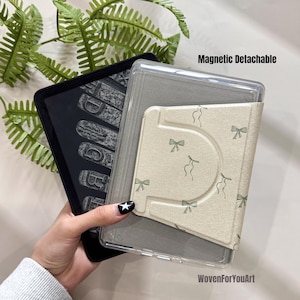 May include: A black e-reader with a clear protective case and a beige cover with a bow pattern. The text "Magnetic Detachable" is visible. The e-reader displays a vintage typewriter font.