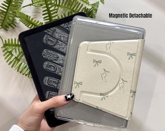 May include: A black e-reader with a clear protective case and a beige cover featuring a bow pattern. The text "Magnetic Detachable" is visible. The e-reader displays a vintage typewriter font.