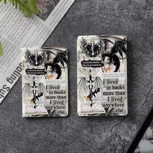 May include: Two rectangular items featuring black and white dragon illustrations, open book graphics, and the text: I lived in books more than I lived anywhere else. Additional text includes: I control the shadows. They do not control me.