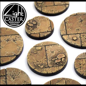 May include: Circular wargame terrain bases with a textured, cracked stone design. The bases are in shades of brown and tan, with a black border. The Light Caster Wargame Terrain logo is visible. Each base is designed for miniature figures.