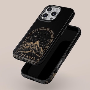 Könnte beinhalten: Schwarze Handyhülle mit einem goldenen Berg- und Sterndesign. Die Hülle trägt den Text "TO THE STARS WHO LISTEN AND THE DREAMS THAT ARE ANSWERED" und "VELARIS CITY OF STARLIGHT". Die Handyhülle wird mit einer zweiten Hülle darunter gezeigt.