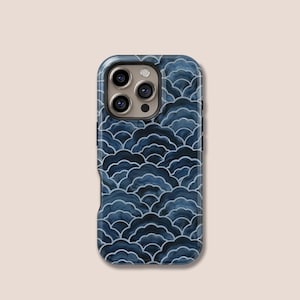Puede incluir: Una funda de teléfono azul marino con un patrón de olas repetidas en un tono más oscuro de azul. La funda tiene un acabado brillante y un recorte para la cámara con tres lentes.