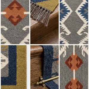 May include: A woven stair runner featuring a geometric pattern in shades of grey, white, navy blue, olive green, and rust orange. The runner includes a fringed edge and is secured with a metallic brass stair rod, showcasing a textured fabric surface.