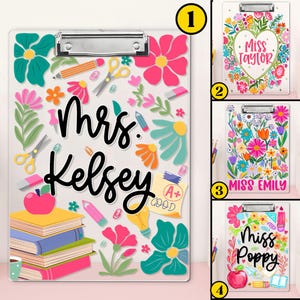 May include: A clear clipboard with a silver clip, decorated with colourful flowers, pencils, scissors, and the name "Mrs. Kelsey" in black script. An apple, books, and a coffee cup are also featured.