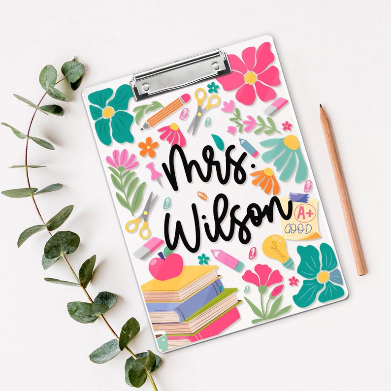 May include: White clipboard with a metal clip, decorated with colourful floral and school-themed illustrations. The clipboard features the name "Mrs. Wilson" in black script, along with pencils, scissors, and an apple.