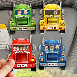 May include: Four colorful truck-shaped car magnets. Each magnet features a different color: green, yellow, red, and blue. Each truck has a picture of children in the cab and the text "DRIVE SAFE" followed by a family member's title.