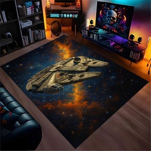 Könnte beinhalten: Ein rechteckiger Teppich mit einer detaillierten Illustration des Raumschiffs Millennium Falcon vor einem Sternenhintergrund mit orangefarbenen und blauen Nebeln. Der Teppich ist für die Inneneinrichtung konzipiert.