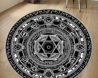 May include: A round black and white rug with a detailed, intricate design. The rug features a central six-pointed star, surrounded by concentric circles filled with symbols and text. The overall pattern is symmetrical and detailed.