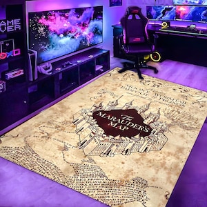 May include: A rectangular rug featuring a map design with a castle illustration at the center. The rug has a parchment-like appearance with text around the edges. The words "The Marauder's Map" are prominently displayed.
