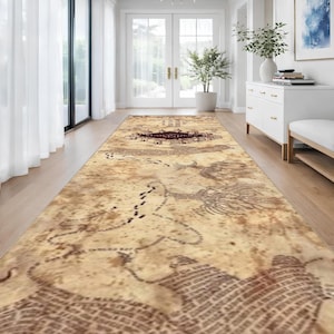 May include: A long rectangular runner rug featuring a vintage-style parchment map design with sepia and brown tones. The surface displays intricate illustrations of winding paths, topographical lines, and a central dark crest with text.