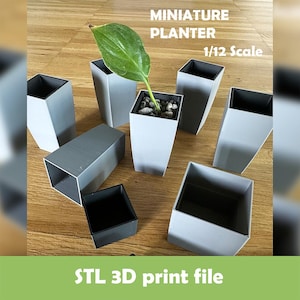 Könnte beinhalten: Miniatur-Pflanzgefäße in Grau, Maßstab 1:12, mit einer Pflanze in einem. Die Pflanzgefäße sind quadratisch und haben eine schwarze Innenseite. Das Bild enthält den Text "MINIATURE PLANTER 1/12 Scale" und "STL 3D print file".