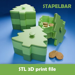Op de afbeelding: Groene, boomvormige containers met deksels, gestapeld en open, met koekjes. De containers zijn in verschillende groentinten, met het woord "STAPELBAR" en "STL 3D print file".