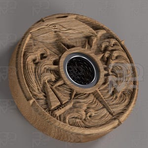 Puede incluir: Un objeto decorativo redondo de madera con un diseño tallado que presenta un pájaro, olas y una abertura central oscura. El objeto es de color marrón claro y parece ser un elemento decorativo.