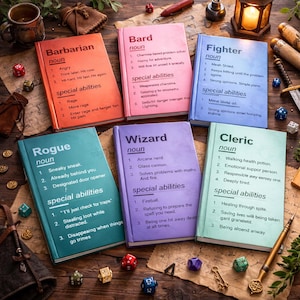 May include: Six books with character class names like 'Barbarian' and 'Wizard' on their covers, each in a different colour. The books list traits and abilities, and are surrounded by dice and fantasy game accessories. The books are on a wooden surface.