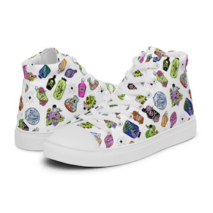 May include: White high-top sneakers with a colorful pattern of potion bottles, skulls, and floral designs. The shoes have white laces and a white rubber sole. The overall design is whimsical and eye-catching.