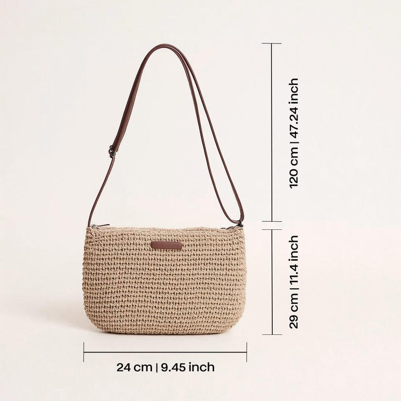 Pu&ograve; includere: Borsa a tracolla beige intrecciata con cinturino in pelle marrone. La borsa &egrave; larga 24 cm, alta 29 cm e il cinturino &egrave; lungo 120 cm. Ha una forma rettangolare con angoli arrotondati e una piccola etichetta in pelle marrone.