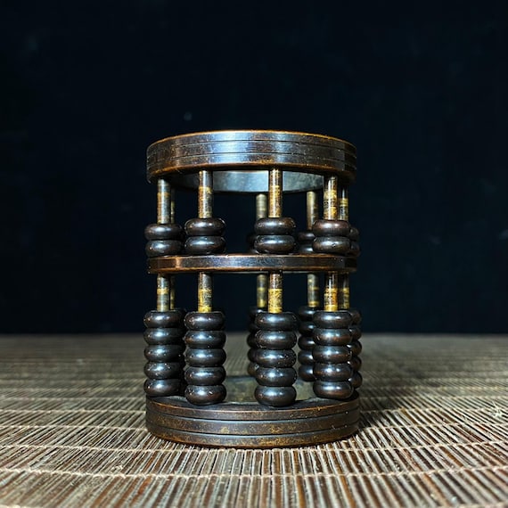 A fully functional brass abacus reimagined as a sculptural pen holder — part calculating tool, part desk statue, all conversation starter.