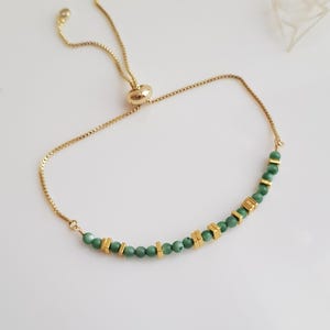 Puede incluir: Pulsera dorada ajustable con una fina cadena. Presenta peque&ntilde;as cuentas verdes redondas y detalles rectangulares dorados. La pulsera tiene un cierre deslizante para un ajuste f&aacute;cil.