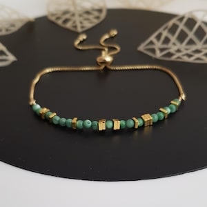 Puede incluir: Pulsera ajustable dorada con cuentas verdes y detalles cuadrados dorados. La pulsera tiene una cadena fina y un cierre deslizante. El dise&ntilde;o es sencillo y elegante, adecuado para el uso diario o ocasiones especiales. La longitud es ajustable.