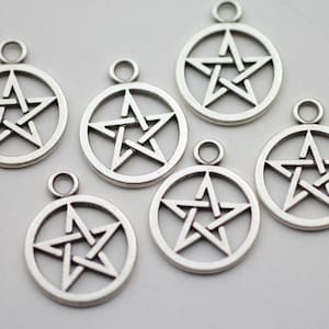May include: Silver-colored pentagram charms. Each charm features a five-pointed star within a circular frame, with a small loop at the top for attaching to jewelry or other crafts. The charms are displayed against a light background.
