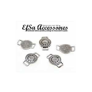 May include: Silver-toned metal jewelry findings. The findings include several round and oval pieces with decorative designs. Some pieces resemble small watch faces with Roman numerals. The text "EfSa Accessoires" is visible.