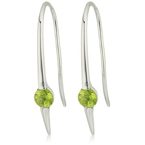 May include: A pair of silver drop earrings. Each earring has a curved hook design, a bright green, round gemstone at the centre, and a pointed, elongated bottom. The earrings are set against a white background.