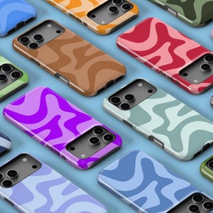 Puede incluir: Una colección de fundas de teléfono coloridas con un diseño de patrón ondulado. Las fundas están disponibles en varios colores, incluyendo azul, verde, marrón, rojo, rosa y morado. Las fundas están diseñadas para un smartphone.
