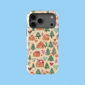May include: A phone case with a festive Christmas pattern. The design features gingerbread houses, Christmas trees, candy canes, and hearts in red, green, and white on a beige background. The case has a camera cutout and buttons.