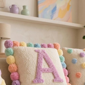 Close-up of handmade tufted cushion cover showing soft plush texture, pastel yarn details, and premium handcrafted workmanship.