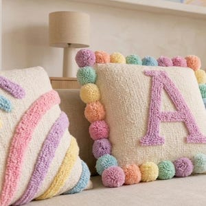Close-up of handmade tufted cushion cover showing soft plush texture, pastel yarn details, and premium handcrafted workmanship.